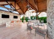 Thumbnail 35 of 49 - a covered patio with a fireplace and bar