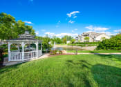 Thumbnail 39 of 49 - a gazebo sits in the middle of a grassy area next to a pond