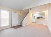Thumbnail 19 of 24 - a bedroom with a staircase and a kitchen in the background