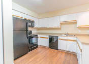 Thumbnail 20 of 24 - a kitchen with white cabinets and black appliances