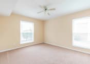 Thumbnail 21 of 24 - a bedroom with two windows and a ceiling fan