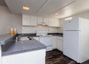 Thumbnail 37 of 42 - a white kitchen with a sink and a refrigerator