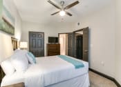 Thumbnail 38 of 54 - a bedroom with a large white bed and a ceiling fan