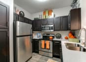 Thumbnail 43 of 54 - a kitchen with stainless steel appliances and black cabinets