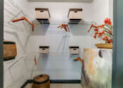 Thumbnail 42 of 54 - a walk in closet and bins on wire racks and a table with flowers