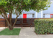 Thumbnail 19 of 42 - a wooden fence in front of an apartment building with a red door