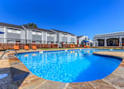 Thumbnail 3 of 42 - a resort style swimming pool with apartments in the background