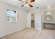 Thumbnail 4 of 17 - a living room with a ceiling fan and a door to a bathroom