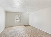 Thumbnail 11 of 17 - a spacious living room with carpet and a door to a bedroom