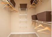 Thumbnail 27 of 28 - A walk-in closet with shelves and hangers.
