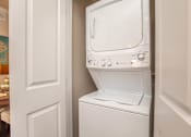 Thumbnail 28 of 28 - A white washing machine in a small laundry room.