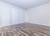 Thumbnail 33 of 42 - an empty room with wood flooring and white walls and doors