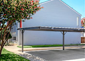 Thumbnail 21 of 42 - a covered parking lot in front of a building