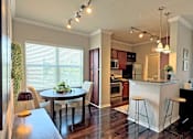 Thumbnail 4 of 26 - A kitchen with a table and chairs in front of a window.