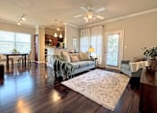 Thumbnail 2 of 26 - A living room with a couch, a rug, and a ceiling fan.