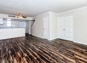 Thumbnail 30 of 42 - an empty living room with a kitchen and a ceiling fan