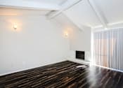 Thumbnail 31 of 42 - a living room with white walls and wood floors and a fireplace