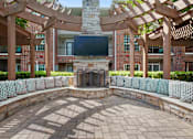 Thumbnail 7 of 40 - a patio with a stone fireplace and a large wooden structure