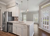 Thumbnail 21 of 40 - a kitchen with white cabinets and a stainless steel refrigerator