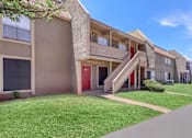 Thumbnail 3 of 37 - Apartment building with a red door and stairs leading to the entrance.