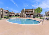 Thumbnail 9 of 37 - A swimming pool in a residential area with houses in the background.