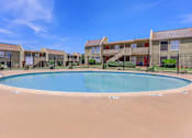 Thumbnail 6 of 37 - a swimming pool with an apartment building in the background
