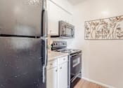 Thumbnail 22 of 37 - a small kitchen with a stove and a refrigerator