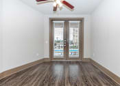 Thumbnail 17 of 48 - a living room with a door and a ceiling fan