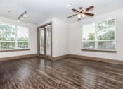 Thumbnail 38 of 48 - an empty living room with a ceiling fan and two windows