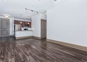 Thumbnail 33 of 48 - a living room and kitchen with white walls and wood floors