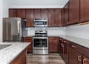Thumbnail 40 of 48 - a kitchen with stainless steel appliances and marble counter tops