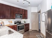 Thumbnail 11 of 48 - a kitchen with stainless steel appliances and wooden cabinets