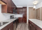Thumbnail 18 of 48 - a kitchen with granite counter tops and wooden cabinets