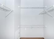 Thumbnail 35 of 48 - a walk in closet with white walls and white shelves