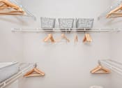 Thumbnail 22 of 48 - a walk in closet with shelves and clothes racks