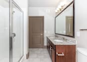 Thumbnail 42 of 48 - a bathroom with a shower and a sink and a mirror