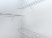 Thumbnail 30 of 48 - a walk in closet with white walls and shelves and a mirrored closet door