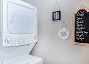 Thumbnail 23 of 48 - the laundry room has a large washer and dryer and a wall mounted tv
