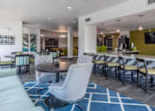 Thumbnail 4 of 48 - a clubhouse with tables and chairs and a bar