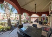 Thumbnail 24 of 54 - a patio with a table and chairs and a palm tree