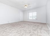 Thumbnail 33 of 43 - A room with a carpeted floor and a ceiling fan.