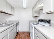 Thumbnail 34 of 43 - a kitchen with white cabinets and appliances and a sink