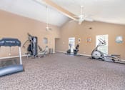 Thumbnail 3 of 43 - a gym with exercise machines and a ceiling fan