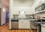 Thumbnail 20 of 34 - A modern kitchen with wooden floors and stainless steel appliances.