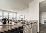 Thumbnail 22 of 34 - A modern kitchen with a black oven and a marble countertop.