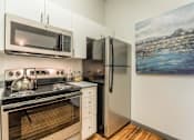 Thumbnail 27 of 34 - A kitchen with a stove, oven, microwave, and refrigerator.