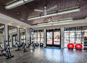 Thumbnail 8 of 34 - A gym with a row of stationary bikes and a mirrored wall.
