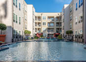Thumbnail 2 of 48 - a swimming pool in front of an apartment building