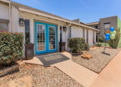 Thumbnail 10 of 54 - the front of a house with a blue door and a sidewalk with plants and balloons