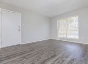 Thumbnail 49 of 54 - an empty living room with wood flooring and a window
